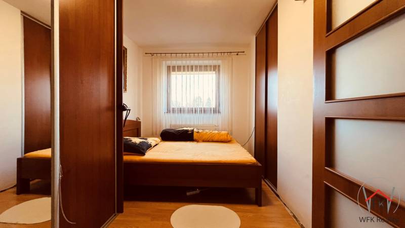 Schlafzimmer in einer 3-Zimmer-Wohnung mit Holzboden und großen Schränken.