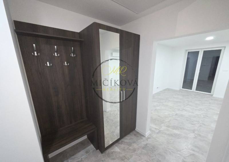 Flur mit Garderobenwand und Spiegel in einem Einfamilienhaus mit Holzboden.