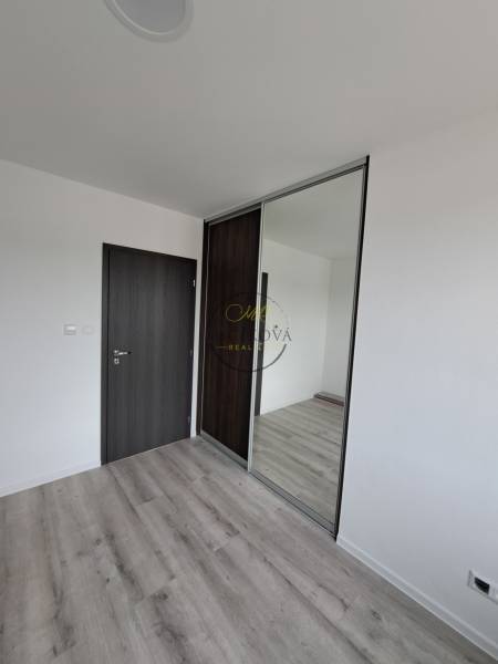 Ein Zimmer mit einem Holzboden, dunklen Türen und einem Einbauschrank in einem Einfamilienhaus.