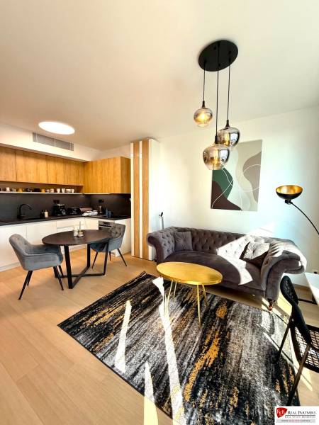 Wohnzimmer in einer 2-Zimmer-Wohnung mit Holzboden und modernen Möbeln.