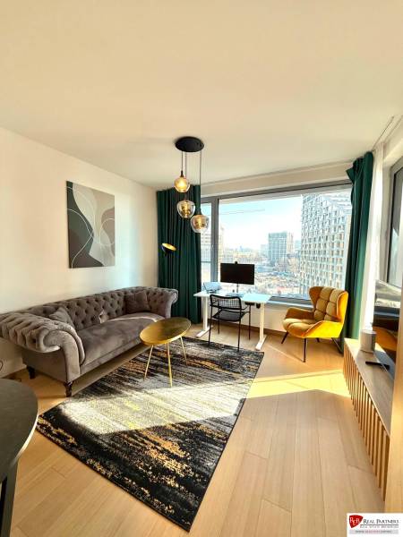 Helles Wohnzimmer mit Sofa und Holzboden in einer 2-Zimmer-Wohnung.