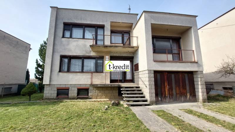Ein Einfamilienhaus in Zlaté Moravce mit Treppe und Balkon, davor befindet sich ein grüner Rasen.