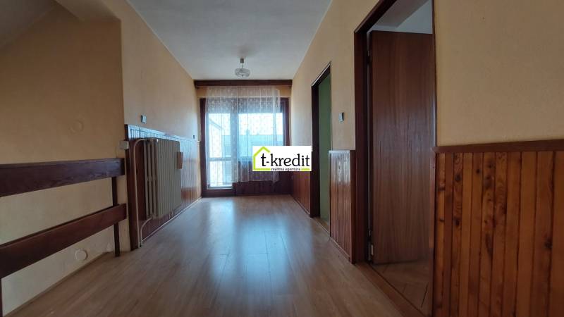 Ein Flur in einem Einfamilienhaus mit einem Boden in Holzoptik und Holzverkleidungen.