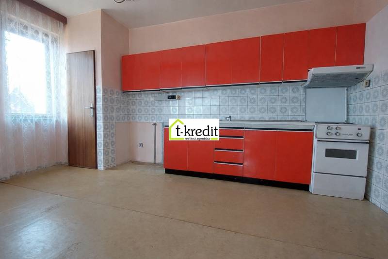 Küche mit roten Schränken, Herd und Fenster in einem Einfamilienhaus.