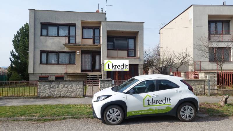 Ein Einfamilienhaus in Zlaté Moravce mit einem vor dem Haus geparkten Auto des Immobilienbüros.