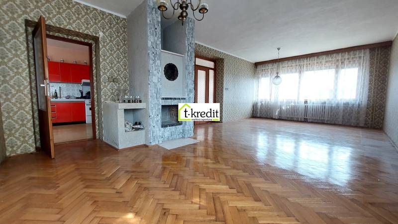 Wohnzimmer in einem Einfamilienhaus mit Kamin und Holzboden.