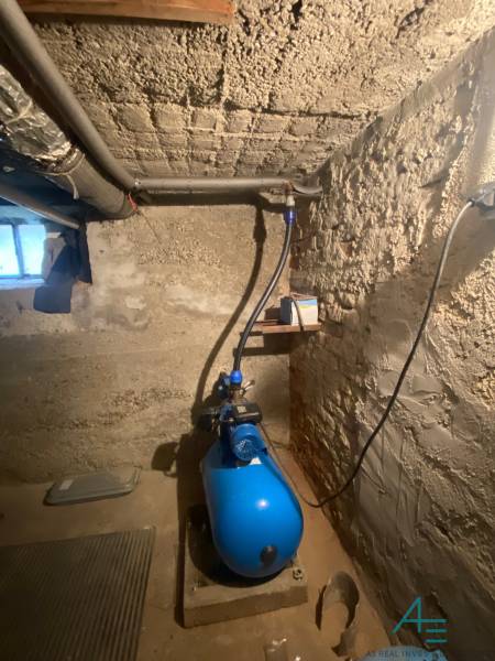 Der Keller des Einfamilienhauses mit einer Pumpe und einfachen Betonwänden.