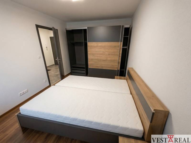 Schlafzimmer mit Doppelbett und Einbauschrank in einer 2-Zimmer-Wohnung.