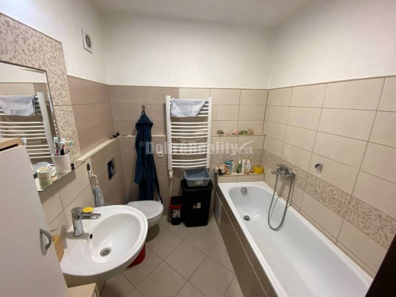 Badezimmer mit Badewanne, Waschbecken und Toilette in einer 4-Zimmer-Wohnung.