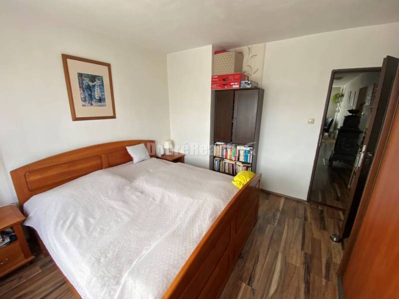 Schlafzimmer in einer 4-Zimmer-Wohnung mit Holzboden und Holzbett.