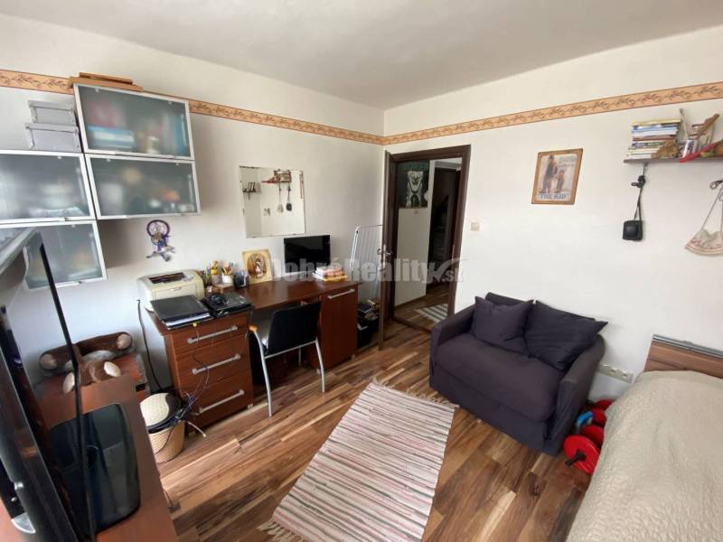 Ein Zimmer mit einem Schreibtisch, Holzboden, befindet sich in einer 4-Zimmer-Wohnung.