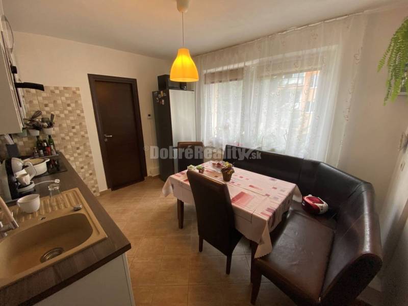 Küche in einer 4-Zimmer-Wohnung mit Essecke und ausziehbarem Sofa.