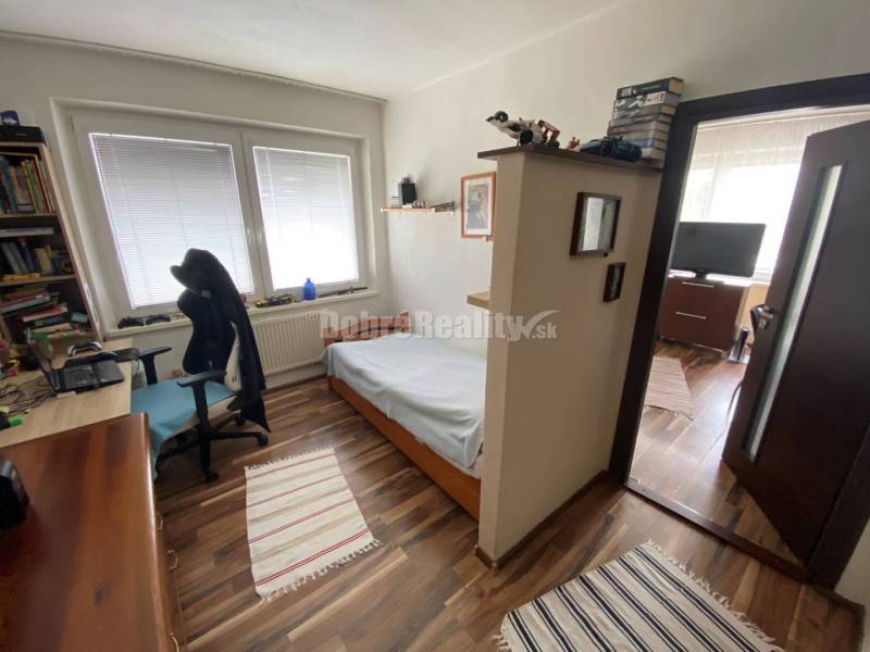 Schlafzimmer mit Bett, Schreibtisch und Boden in Holzoptik, 4-Zimmer-Wohnung.