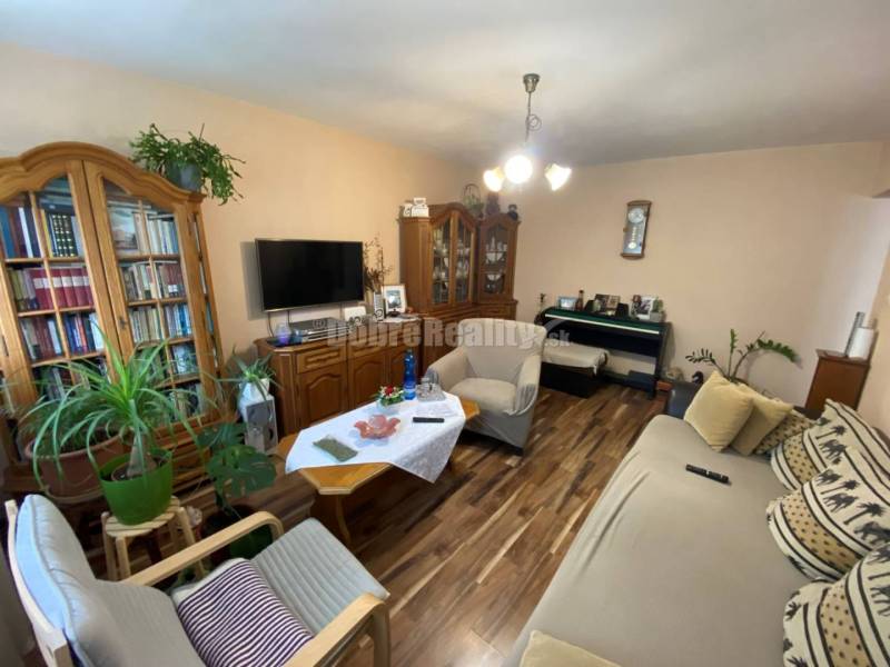 Wohnzimmer in einer 4-Zimmer-Wohnung mit bequemen Sesseln und einem Boden in Holzoptik.