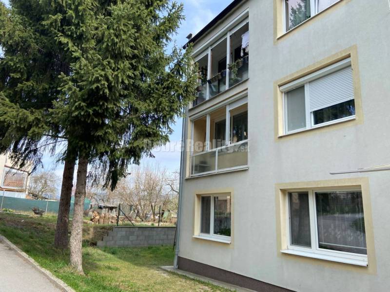 Ein Gebäude mit einer 4-Zimmer-Wohnung in der Sobôtka-Straße, Rimavská Sobota, umgeben von Grünflächen und Bäumen.