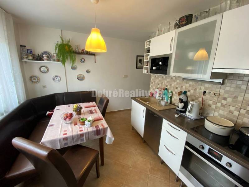 Küche in einer 4-Zimmer-Wohnung mit Eckbank, Keramiktellern an der Wand und Geräten.