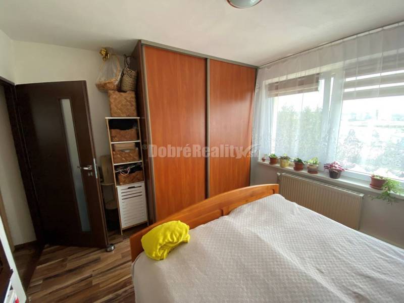 Schlafzimmer in einer 4-Zimmer-Wohnung mit einem großen Einbauschrank und einem Boden in Holzoptik.