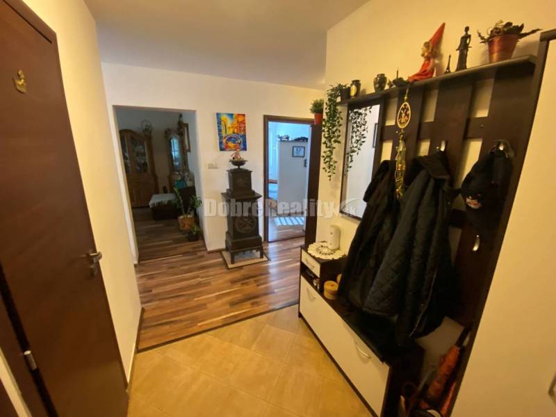 Der Flur in einer 4-Zimmer-Wohnung mit einem Boden in Holzoptik und einer Garderobenwand.