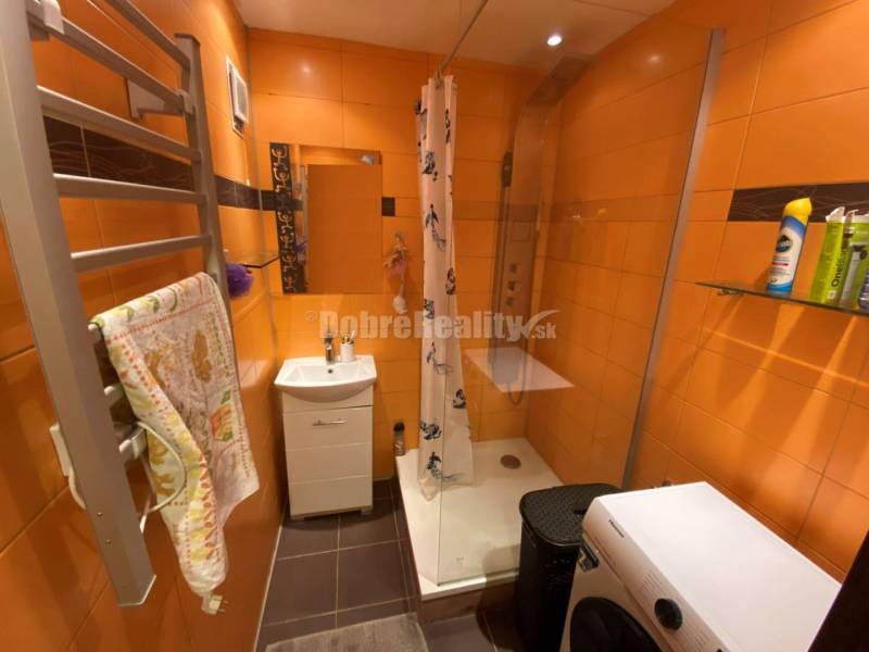 Badezimmer in einer 4-Zimmer-Wohnung mit Duschkabine und orangefarbenen Fliesen.