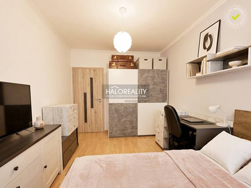 Schlafzimmer in einer 2-Zimmer-Wohnung mit Holzboden und Stauraum.