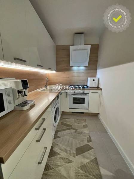 Küche in einer 2-Zimmer-Wohnung mit Holzboden und Geräten.