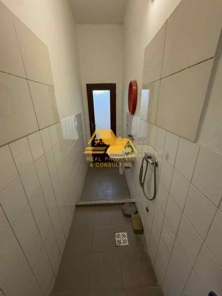 Ein schmales Badezimmer in einem Studio-Apartment, mit Fliesen an den Wänden und einem Fliesenboden.