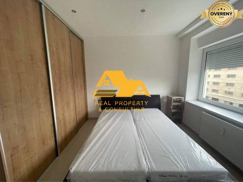 Schlafzimmer in einer 3-Zimmer-Wohnung mit Bett, Einbauschrank und Fenster mit Aussicht.