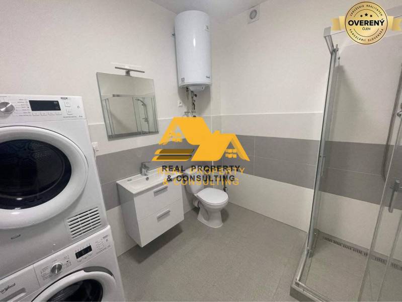 Badezimmer mit Dusche, Waschmaschine und Waschbecken in einer 3-Zimmer-Wohnung.