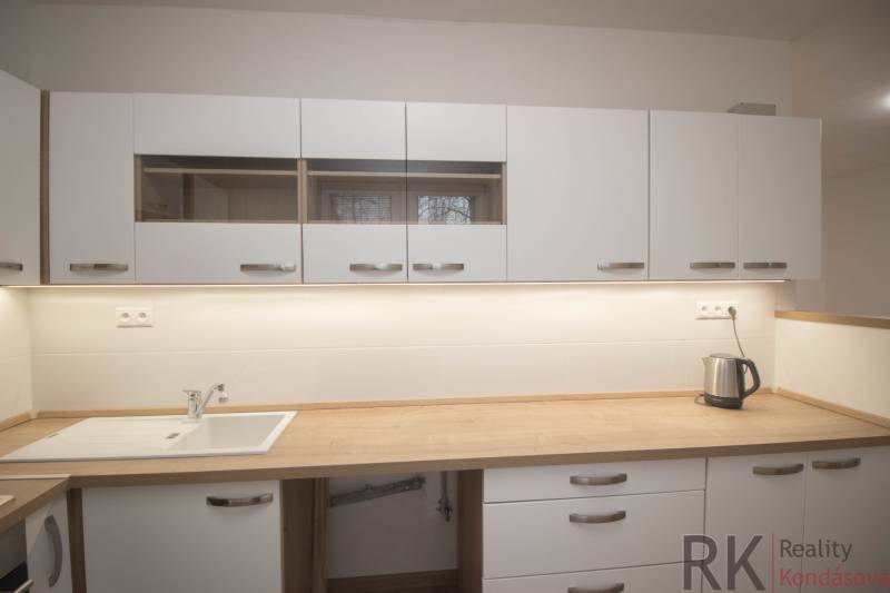 Küchenzeile in einer 2-Zimmer-Wohnung mit Holzdekor-Arbeitsplatte.