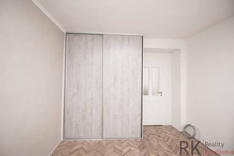 Ein Kleiderschrank mit Schiebetüren in einer 2-Zimmer-Wohnung, ein Boden mit Holzdekor.