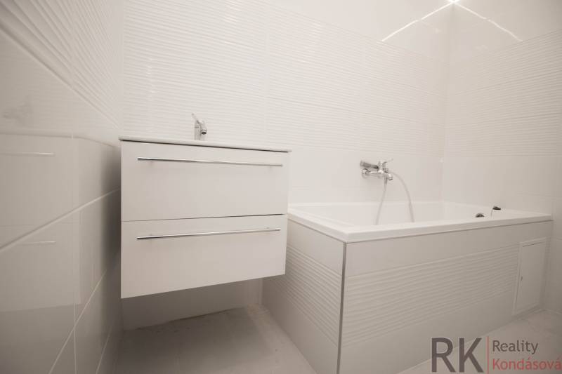 Elegantes Badezimmer mit weißem Waschbecken und Badewanne in einer 2-Zimmer-Wohnung.