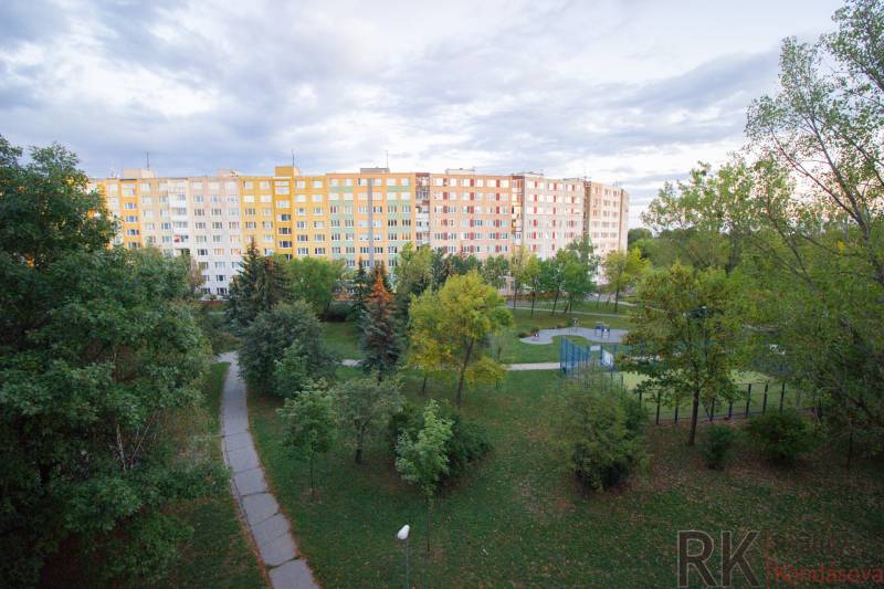 Ein großes Wohnhaus umgeben von Bäumen und gepflegten Gehwegen in der Krakowská in Košice.