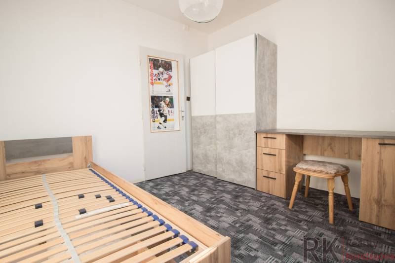 Schlafzimmer in einer 4-Zimmer-Wohnung mit Bett, Schreibtisch und Kleiderschrank.