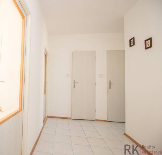 Flur mit hellen Wänden und weißen Türen in einer 4-Zimmer-Wohnung.