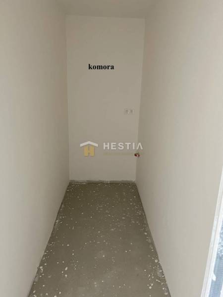 Ein kleiner Abstellraum in einer 2-Zimmer-Wohnung mit weißen Wänden und Betonboden.