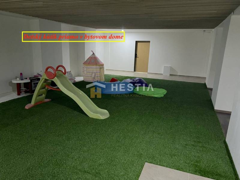 Kinderecke mit Kunstrasen, Rutsche und Zelt in einer 2-Zimmer-Wohnung.
