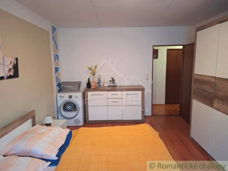 Schlafzimmer im Einfamilienhaus mit Waschmaschine, Schrank und Dekor aus Holzboden.