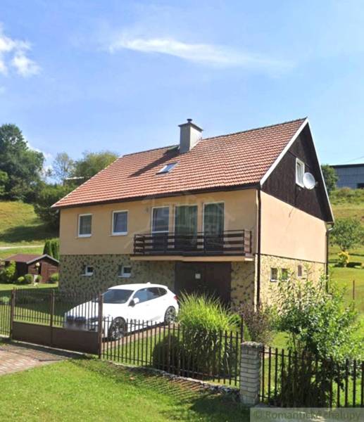 Ein Einfamilienhaus in Liptovské Revúce mit Garage und Garten auf einem Hanggrundstück.