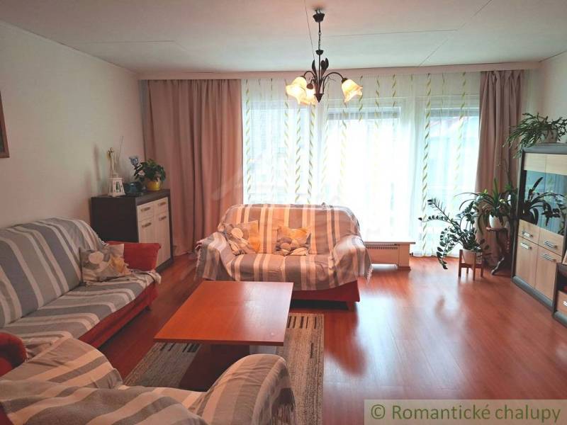 Wohnzimmer in einem Einfamilienhaus mit Holzboden, Licht und Sofas.