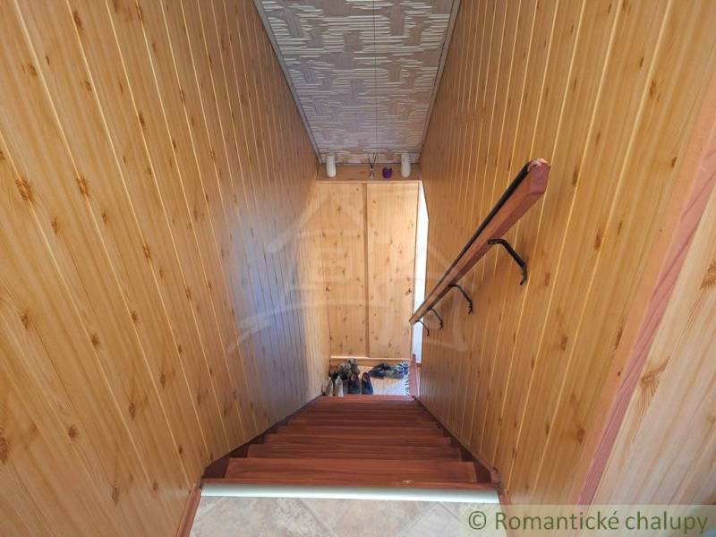 Innenraum eines Einfamilienhauses mit Holzverkleidung an den Wänden und einer Treppe mit Holzdekor.