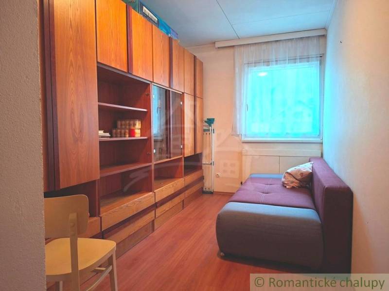 Ein Zimmer mit einem Sofa, Schränken und einem Holzboden in einem Einfamilienhaus.