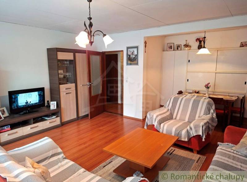 Wohnzimmer in einem Einfamilienhaus mit bequemen Sofas und einem Boden in Holzoptik.