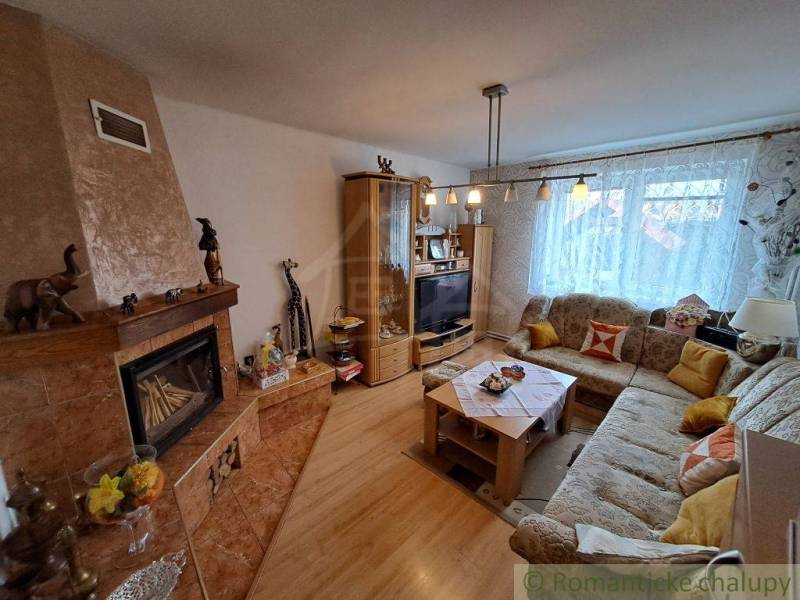 Wohnzimmer in einem Einfamilienhaus mit Kamin, Sofa und Holzboden.