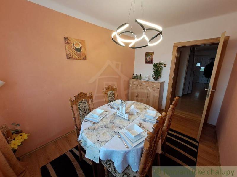 Der stilvolle Speisesaal eines Einfamilienhauses, hervorgehoben durch ein leichtes und ordentliches Tischtuch, aber auch durch ein außergewöhnliches Licht.