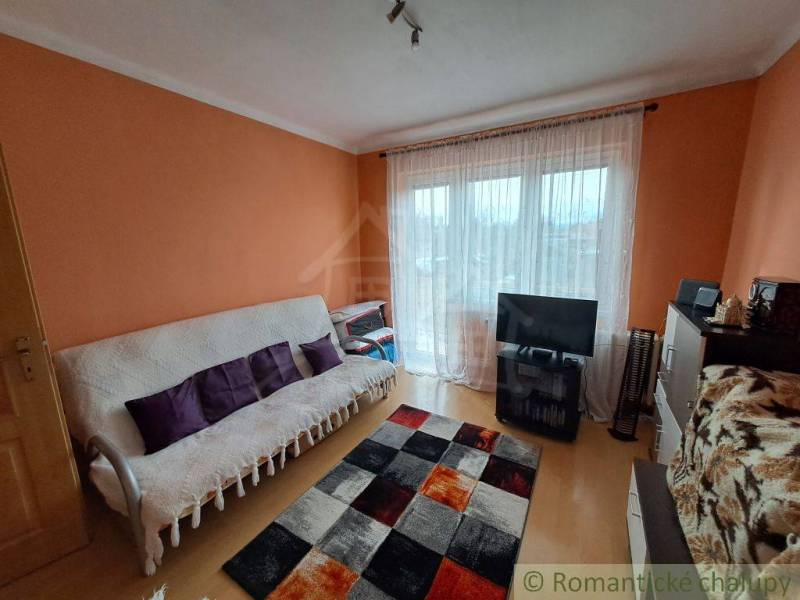 Wohnzimmer in einem Einfamilienhaus mit Holzboden und orangefarbenen Wänden.