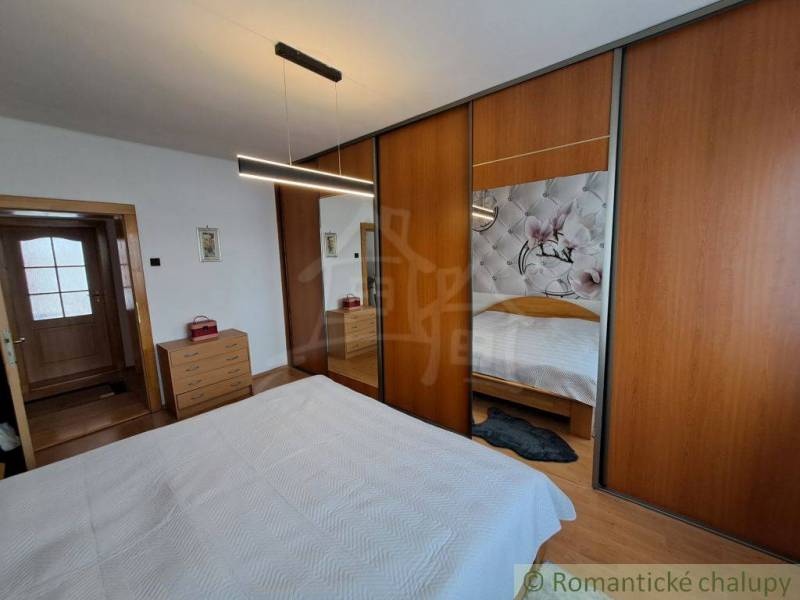 Schlafzimmer in einem Einfamilienhaus mit Holzboden und einem großen Schrank.