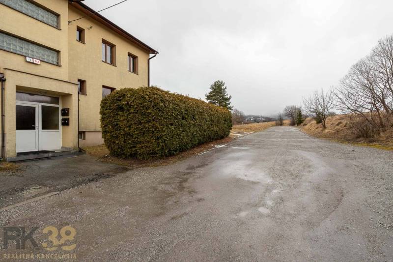 Außenansicht einer 5- oder mehr-Zimmer-Wohnung in Stará Lesná mit sichtbaren Büschen und einer Straße.
