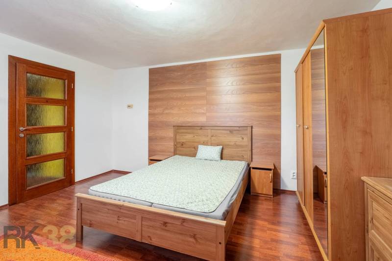 Schlafzimmer in einer Wohnung mit 5 oder mehr Zimmern mit Holzboden, Holzmöbel.