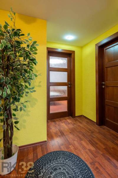 Flur in einer 5- oder mehr-Zimmer-Wohnung mit Holzboden und gelben Wänden.