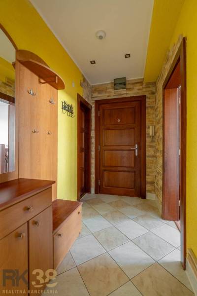 Eingangshalle in einer Wohnung mit 5 oder mehr Zimmern mit gelben Wänden und Holztüren.